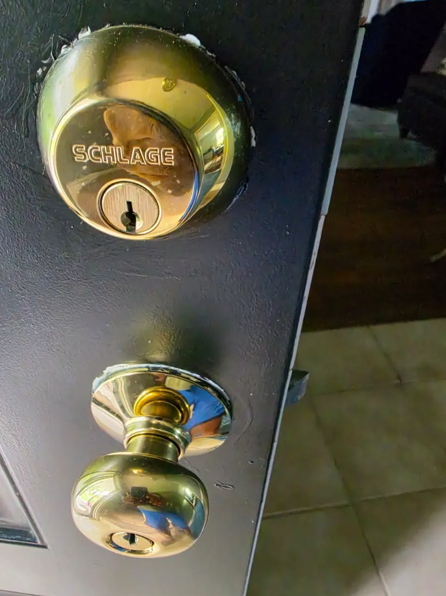 Brass deadbolt and matching knob on a dark front door