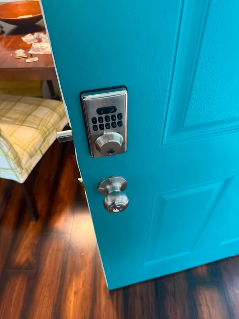 Keypad deadbolt and a stainless knob on a turquoise front door